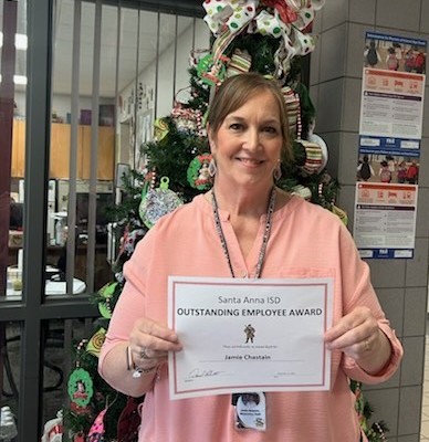 lady holding "Outstanding Employee Award" in front of Christmas tree